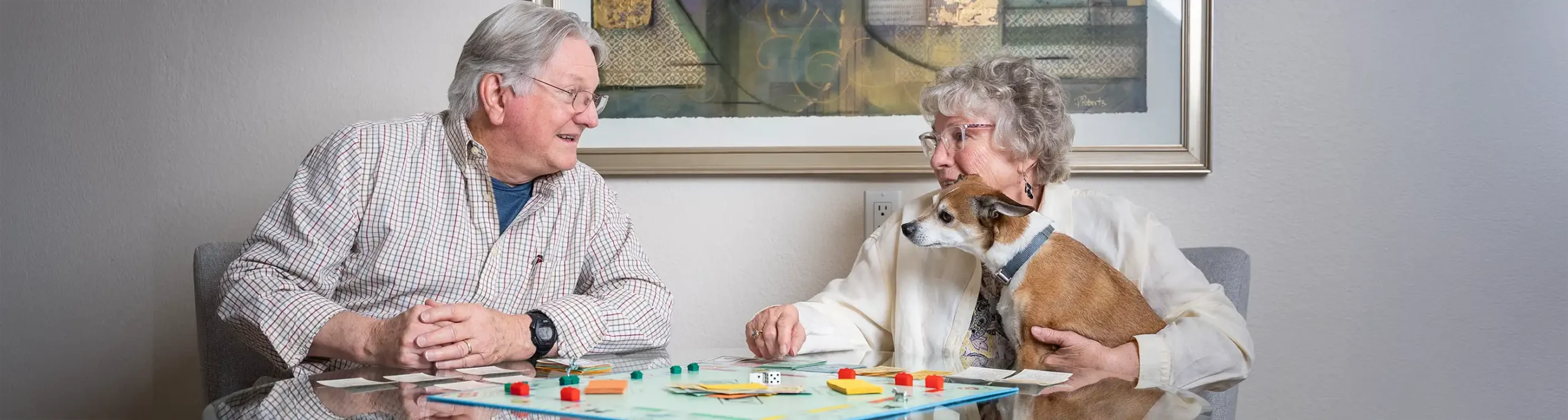 Frequently Asked Questions - FAQ topic showing couple playing a game with a dog on the woman's lap